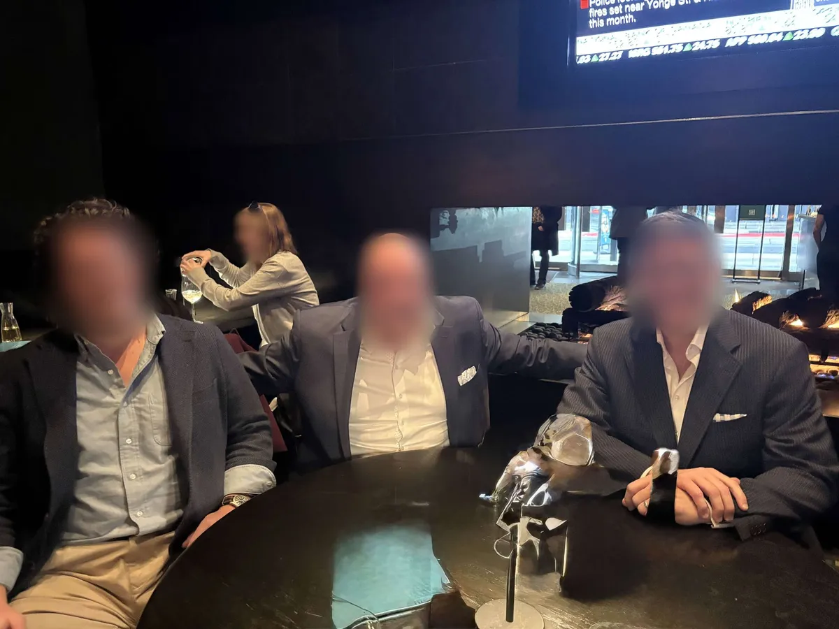 Three members in jackets at a table in a bar
