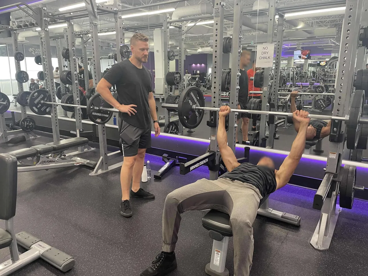 A member spotting another on the bench press