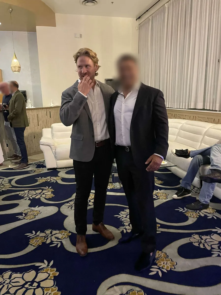 Trav and a member in jackets at an evening event